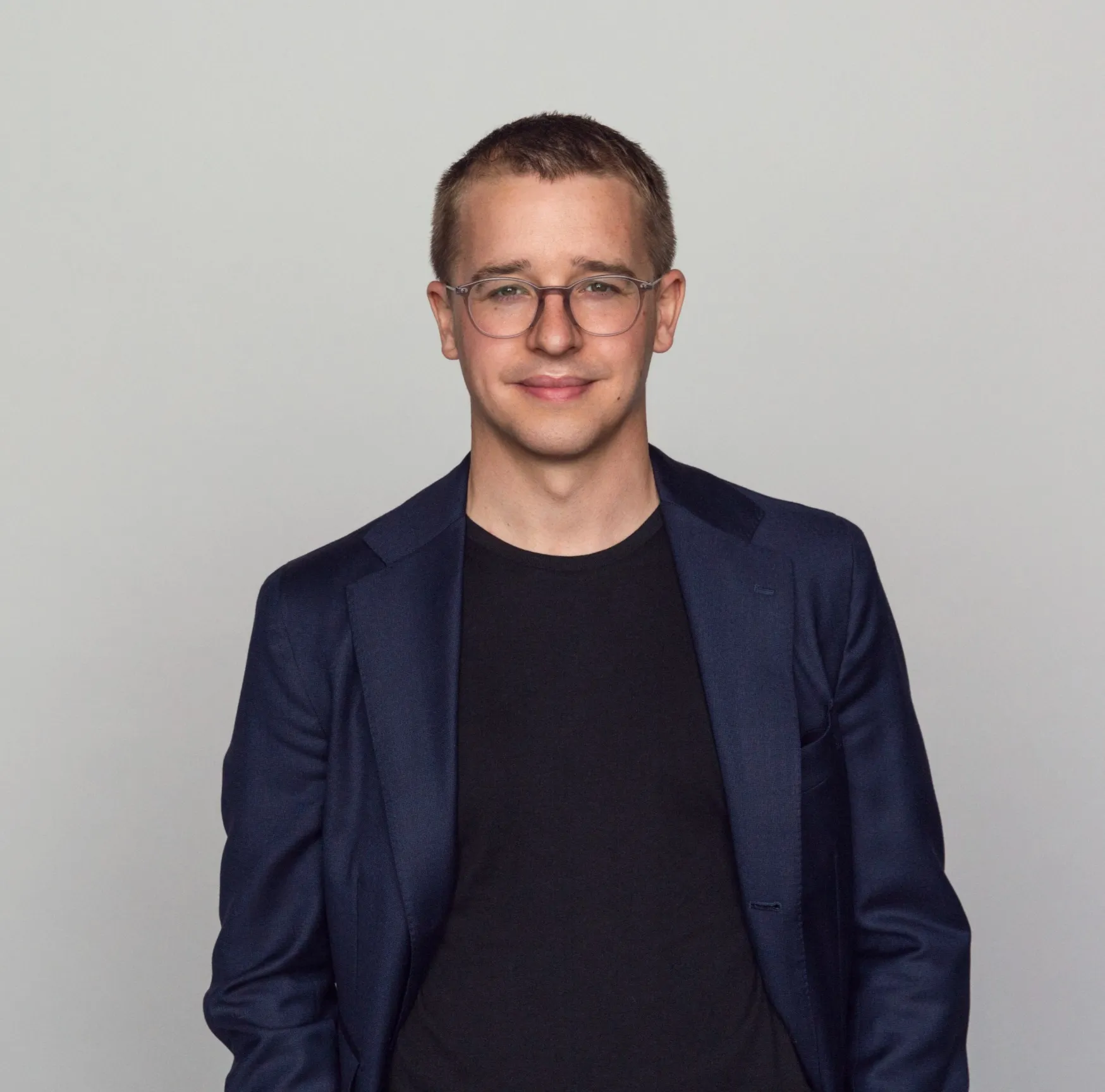 Psykologen Niklas Laninge på porträttbild i mörk kavaj och glasögon