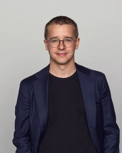 Foto på beteendevetaren Niklas Laninge i mörkblå kavaj mot ljusgrå bakgrund