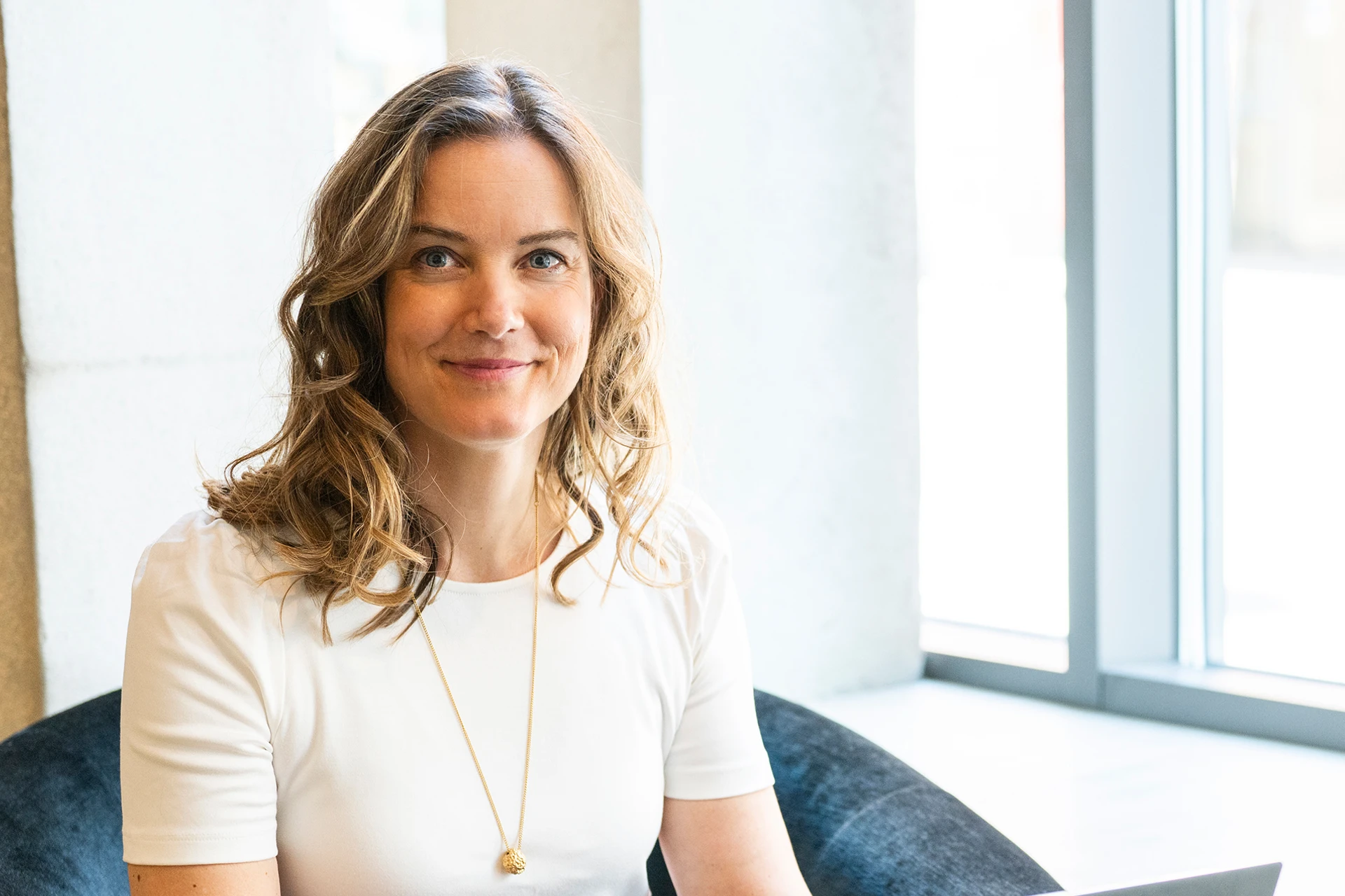 Nina Modig sitter och skriver iklädd en ljus t-shirt