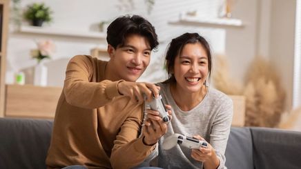 A man and a woman playing video games at home.