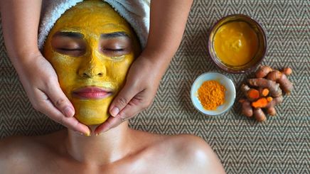 Asian woman in a spa with turmeric face mask.