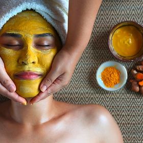 Asian woman in a spa with turmeric face mask.