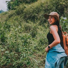Asian woman with a backpack hiking.