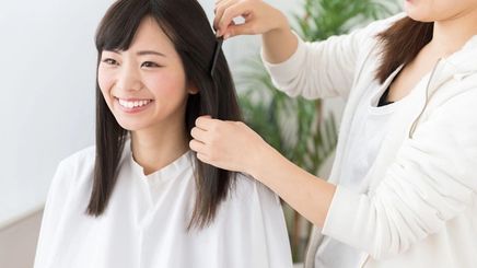 Asian woman getting a haircut from an Asian hair stylist
