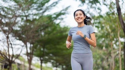 A fit Asian woman jogging outdoors. 