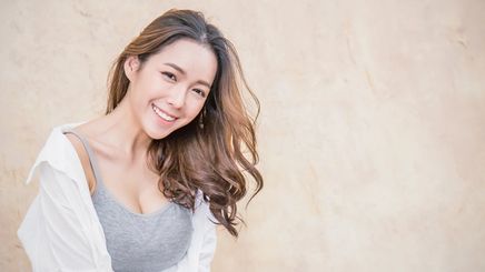 Asian woman in tank top and shirt with soft curls
