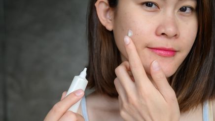 A woman applying a product to treat her skin 