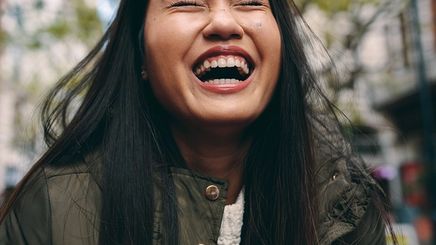 Asian woman laughing hard