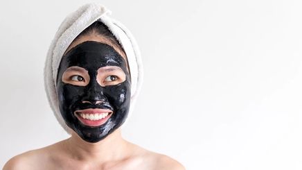 Asian woman using a activated charcoal as a mask