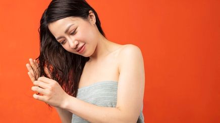 Asian woman touching wet hair