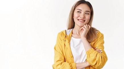 Young Asian woman with blonde hair wearing a yellow windbreaker