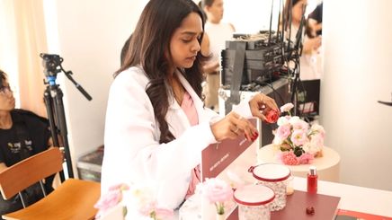 Woman in white testing beauty products at an event.