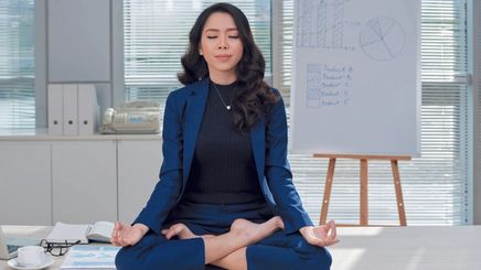 Asian businesswoman meditating at work