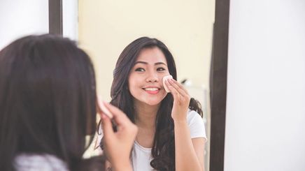 Asian woman applying makeup 