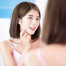 Asian girl looking at a mirror