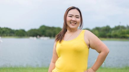 Plus size Asian woman in yellow sleeveless top 