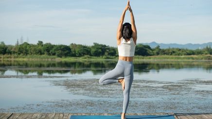 Asian woman yoga pose by the lake