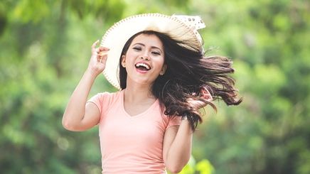 Asian woman flipping hair outdoors