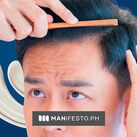Man brushing his black hair with a wooden comb.