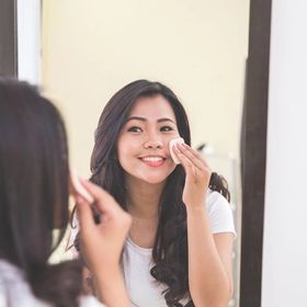 Asian woman applying makeup 