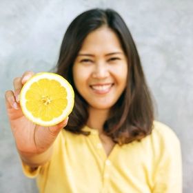 Asian woman holding half an lemon