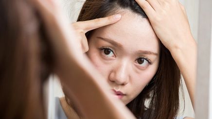 Asian woman looking at scalp