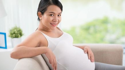 Photo of pregnant Asian woman washing her face with skincare for pregnant women