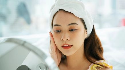 Asian woman applying skin care