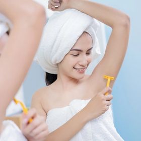 Asian woman shaving armpits