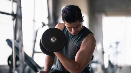 Man using dumbbell exercise to work his biceps at the gym.