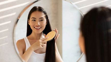 Asian woman brushing long hair