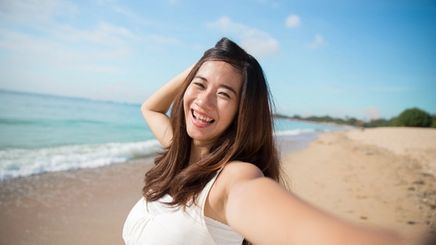 Happy Asian woman at the beach