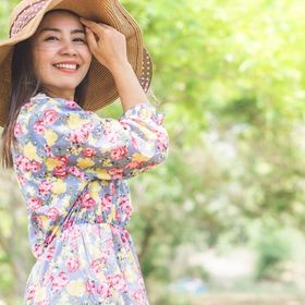 Woman outdoors wearing a sundress and wide hat