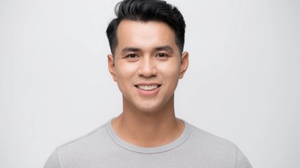 A handsome Asian man smiling and wearing a plain gray t-shirt