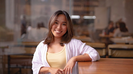 Filipina woman in a yellow top smiling.