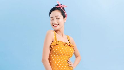 Asian woman in yellow sleeveless dress