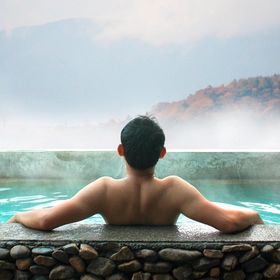 Back of an Asian man relaxing in a hot bath.