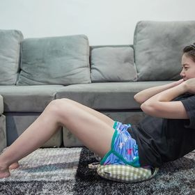 Asian woman working out in living room