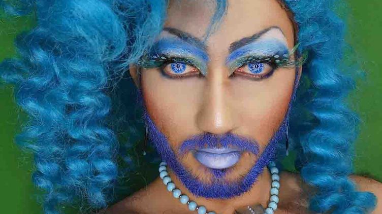Portrait of a young drag queen in full makeup and blue hair