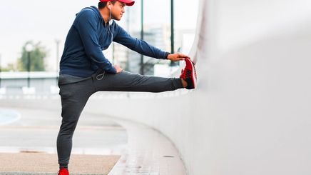 Man stretching his leg before jogging outdoors.