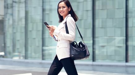 Asian woman in a white blazer crossing the street