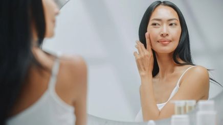 Asian woman in front of mirror