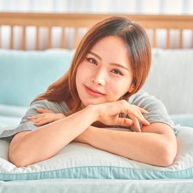 Smiling woman lying on her stomach on the bed.