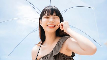 Asian woman holding an umbrella under the sun