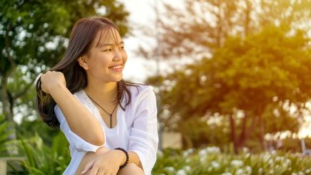 Asian woman happy and smiling outdoors
