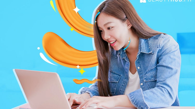 Happy Asian woman looking at laptop
