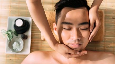 An Asian man getting a face massage 