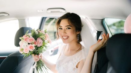 Asian bride smiling inside car