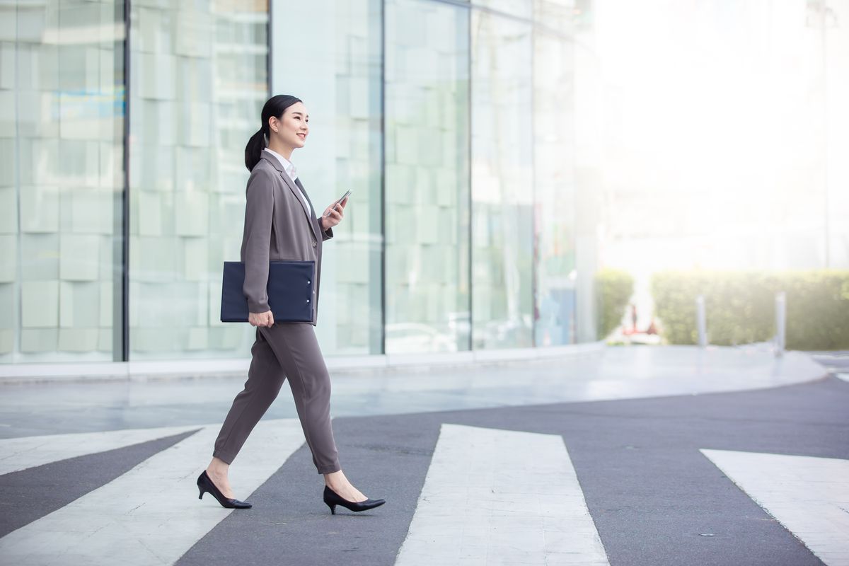 Woman walk. Walk to work. Walking worker. With Handbag standing woman back view.