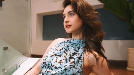 A portrait of Coleen Garcia with long hush cut hair sitting on staircase.